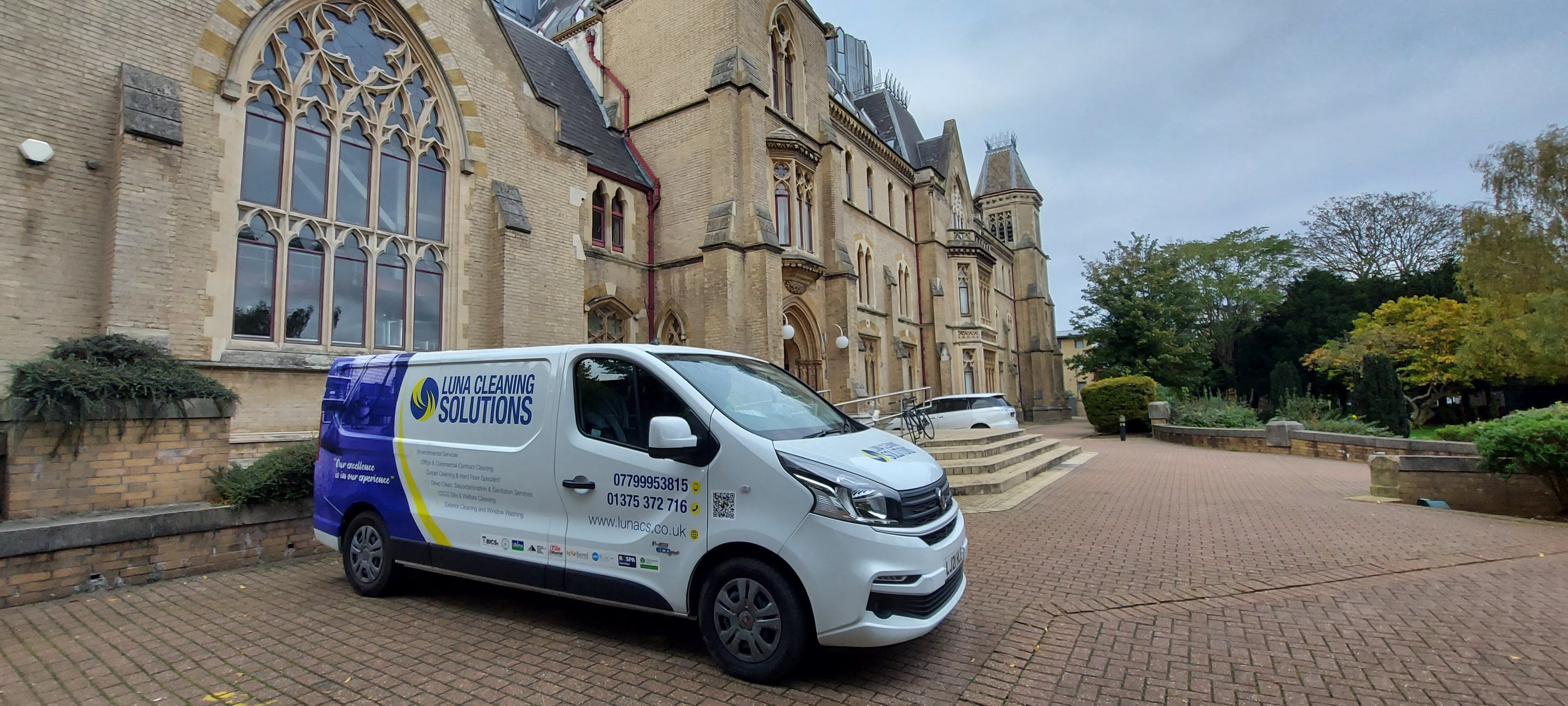 A Luna Cleaning Solutions branded van parked outside a building